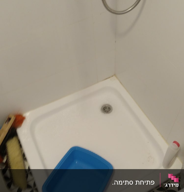 מגש כחול במקלחת עם צינור מים